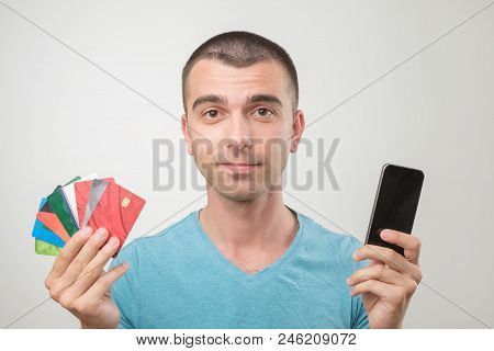 Close Up Portrait Of Young Man In Glasses Holding A Lot Of Gredit Cards And Phone. Concept Of Non Ca