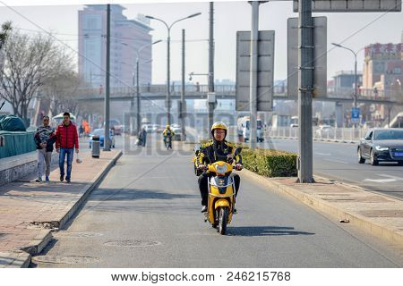 Beijing, China - March 14, 2016: People Are Driving Through The Streets With Bicycles, Scooters And 