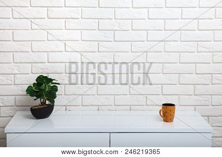 White Table Near The White Wall. Empty Workplace In The Room. White Background Mock Up.