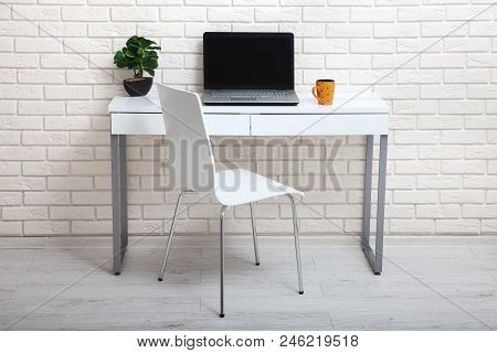 White Table Near The White Wall. Empty Workplace In The Room. White Background Mock Up.