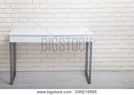 White Table Near The White Wall. Empty Workplace In The Room. White Background Mock Up.