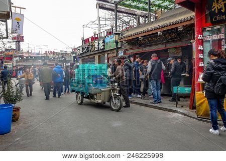 Beijing, China - March 12, 2016: People Are Driving Through The Streets With Bicycles, Scooters And 