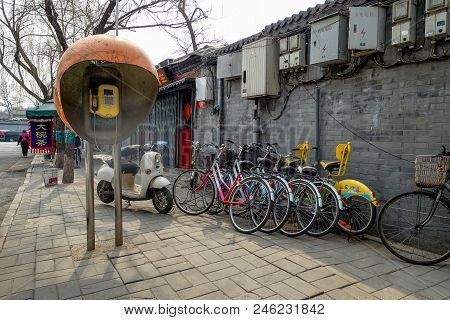 Beijing, China - March 12, 2016: Bicycles, Scooters And Cars In Beijing Streets.  Bicycle Parking.