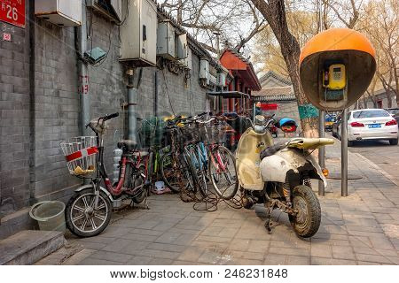 Beijing, China - March 12, 2016: Bicycles, Scooters And Cars In Beijing Streets.  Bicycle Parking.