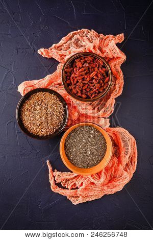 Super Foods - Chia Seeds, Flax Seeds And Goji Berries In Three Ceramic Bowls