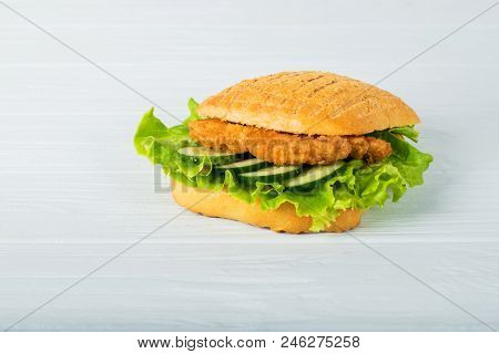 Pressed And Toasted Double Panini With Ham And Cheese Served On Sandwich Paper On A Wooden Table