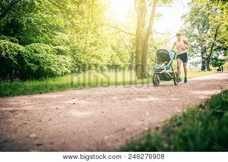 Running Woman With Baby Stroller Enjoying Summer Day In Park. Jogging Or Power Walking Supermom, Act