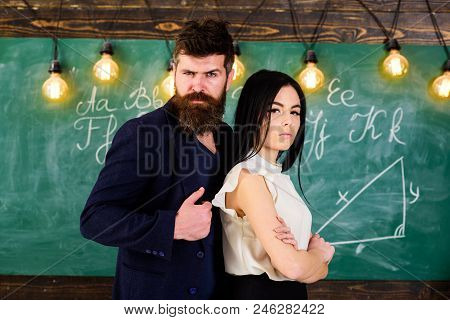 Teacher And Strict Schoolmaster Look Confident. Lady And Hipster Working Together In School.