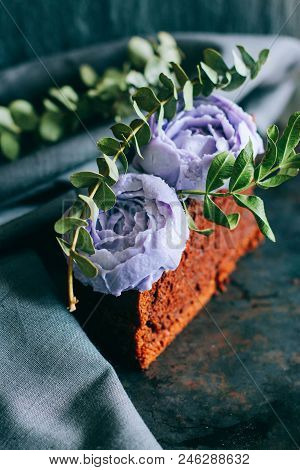 Piece Of Birthday Chocolate Cake With Purple Cream Roses