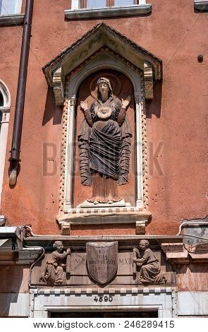 Architectural Detail, A Stone Bas-relief Of The Virgin Mary And Little Jesus On The Wall Of A House 