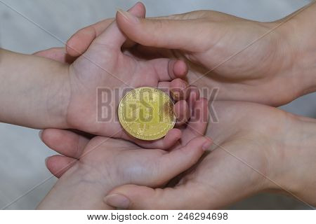 Bitcoin Concept. Children Share Bitcoin. Child Hand And Bitcoin
