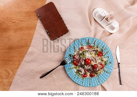 A Plate With Caesar Salad Is Served On The Table, Covered With The Beige Table Cloth.