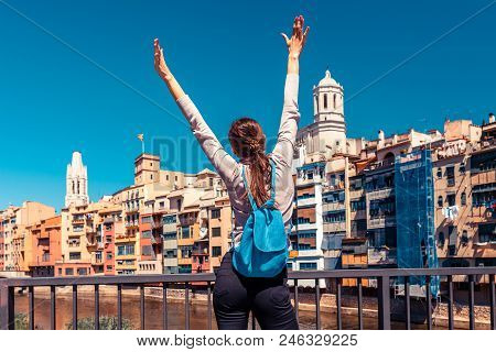 Tourist Woman See On Colorful Red And Yellow Houses And Bridge River Onyar In Girona, Catalonia, Spa