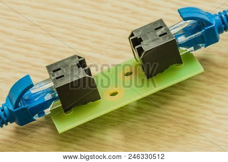 Closeup Of Homemade Ethernet Cable Connector With Blue Ethernet Cables Plugged In Each Connector.