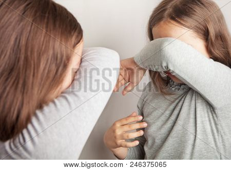 The Girl Cries, Covering Her Face With Her Hand, Standing In Front Of The Mirror.