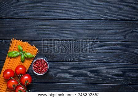 Organic Spaghetti With Fresh Cherries, Red Pepper In Little Glass Bowl And Basil Leaf On Black Woode