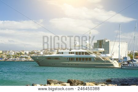 Luxury British Yacht Anchored In The Port Heraclion, Sun And Clouds Baxkground