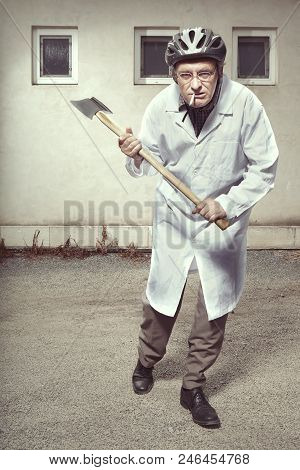 Older Paramedic Freak Man In Medical Coat And Protective Helmet Attacking With Double Axe