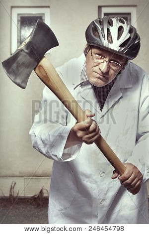 Older Paramedic Freak Man In Medical Coat And Protective Helmet Became Angry With Double Axe