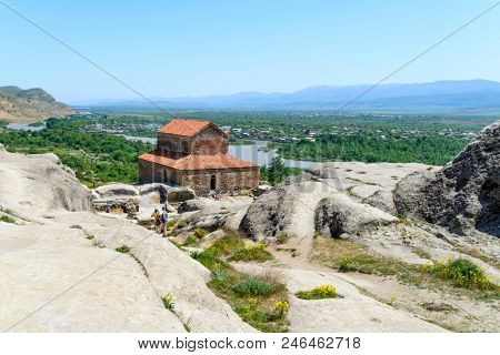 UPLISTSIKHE - MAY 5: Tourists enjoy the sunny weather and walk around the ancient rock city on 5 May 2018 in Uplistsikhe (Upliscyche), Georgia