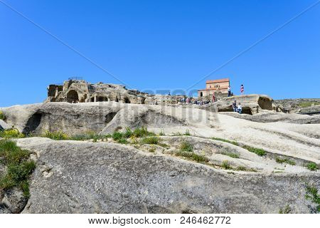 UPLISTSIKHE - MAY 5: Tourists enjoy the sunny weather and walk around the ancient rock city on 5 May 2018 in Uplistsikhe (Upliscyche), Georgia