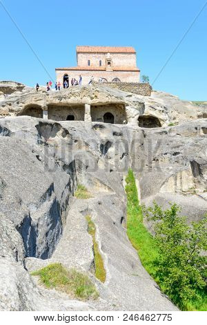 UPLISTSIKHE - MAY 5: Tourists enjoy the sunny weather and walk around the ancient rock city on 5 May 2018 in Uplistsikhe (Upliscyche), Georgia