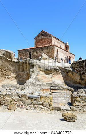 UPLISTSIKHE - MAY 5: Tourists enjoy the sunny weather and walk around the ancient rock city on 5 May 2018 in Uplistsikhe (Upliscyche), Georgia
