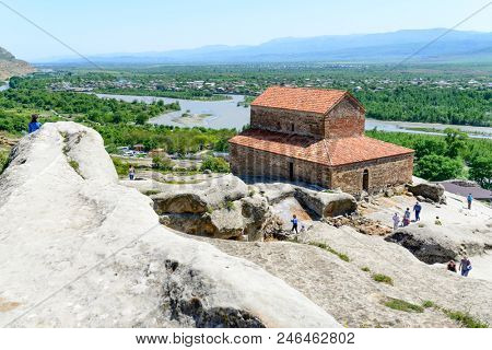UPLISTSIKHE - MAY 5: Tourists enjoy the sunny weather and walk around the ancient rock city on 5 May 2018 in Uplistsikhe (Upliscyche), Georgia