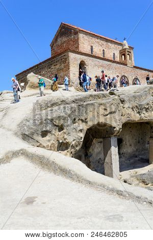 UPLISTSIKHE - MAY 5: Tourists enjoy the sunny weather and walk around the ancient rock city on 5 May 2018 in Uplistsikhe (Upliscyche), Georgia