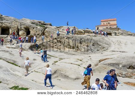 UPLISTSIKHE - MAY 5: Tourists enjoy the sunny weather and walk around the ancient rock city on 5 May 2018 in Uplistsikhe (Upliscyche), Georgia