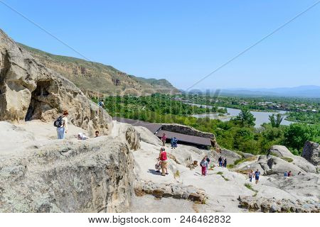 UPLISTSIKHE - MAY 5: Tourists enjoy the sunny weather and walk around the ancient rock city on 5 May 2018 in Uplistsikhe (Upliscyche), Georgia