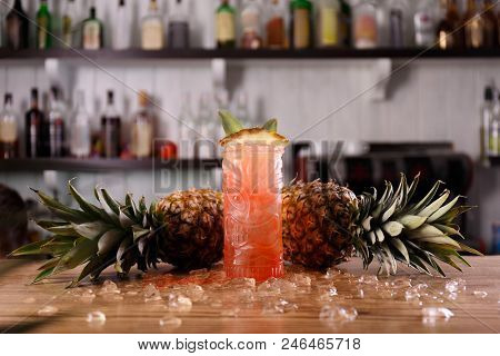 A Red Pina Colada Coctail Is Decorated With Symetrically Lying Ripe Pineapples And Ice.