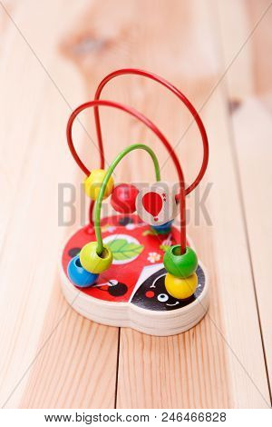 A Wooden Toy In The Form Of A Ladybird With Colourful Wire Is Standing On The Table.