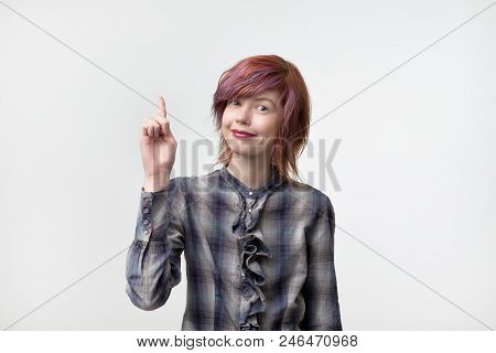 Portrait Of Unusual Informal Pretty Woman With Colorful Hairstyle Pointing With Finger Up. Pay Atten