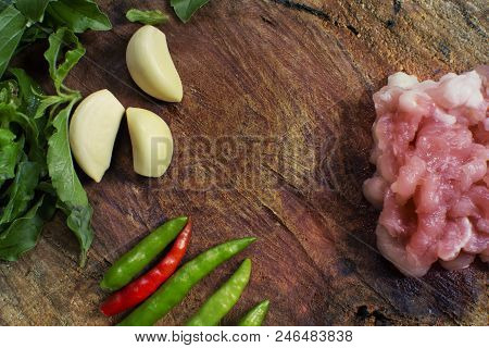 Raw Material Of Stir Fried Pork And Basil Such As Pork,basil,chilli,garlic On A Wooden Chopping Boar