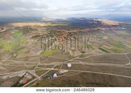The Country Road Leads To The Village Through A Brown Valley And Fields Between The Mountains, A Vie