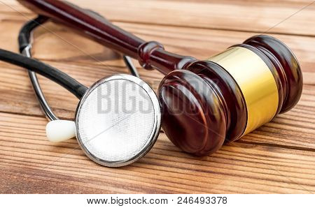 Gavel With Stethoscope On Wooden Table. Medical Law.
