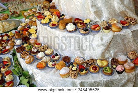 Small Pastries And Cream Puffs Stuffed With Creams And Fruits At A Company Buffet