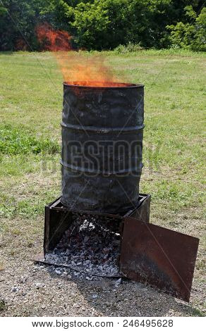 Sheet Metal Bin With Flames Of Fire Used As A Cooking Stove