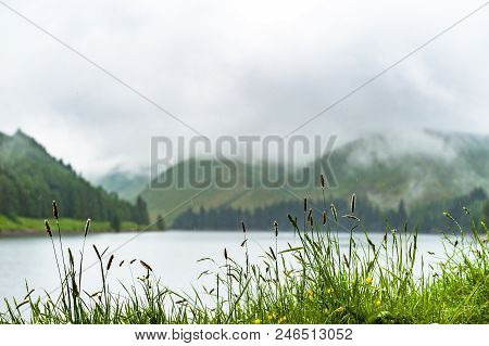 View Of A Beautlful Lake Talla In Scottish Borders With Green Hills Covered By Thick Rainy Clouds.