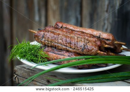 Lulya Kebab From Meat On A White Plate And Wooden Board