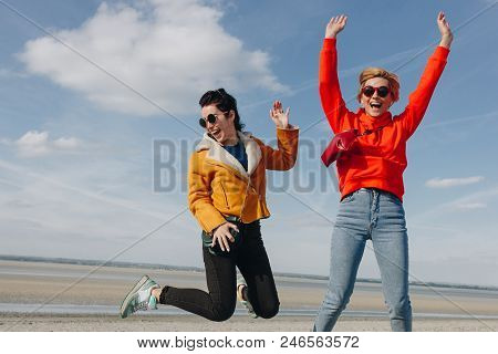 Happy Girls Jumping On Sandy Beach, Saint Michaels Mount, Normandy, France