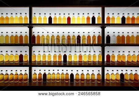 Colorful Whiskey Bottles On Shelf Against Bright White Light