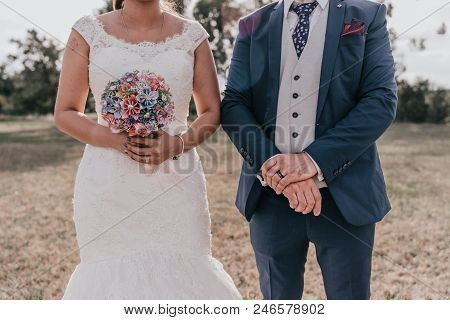Young Couple Holding Hands On Their Wedding Day
