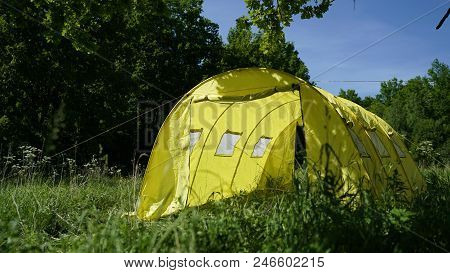 A Large Yellow Tent In The Forest.