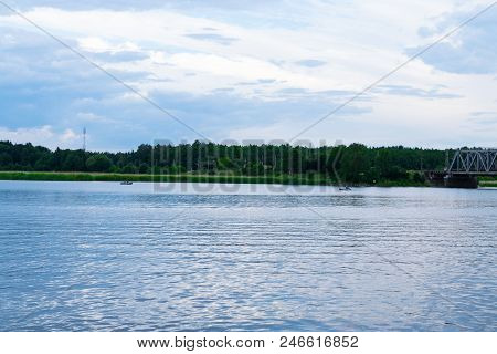 Picturesque Forest , Blue Sky And The River. Fishermen In Their Boat