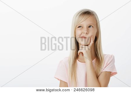 Portrait Of Thougtful Creative Young Girl With Long Blond Hair, Looking Up And Holding Hand On Chin 