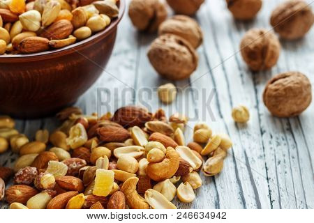 Mix Nuts In Earthenware On A Wooden Background.