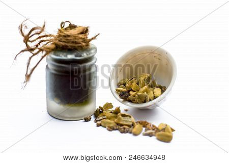 Green Colored Dry Fruit Essence Of Green Cardamom Or Elaichi Isolated On White In Transparent Bottle