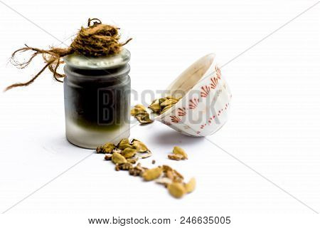 Green Colored Dry Fruit Essence Of Green Cardamom Or Elaichi Isolated On White In Transparent Bottle